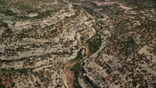 AX136_124E - 5.5K aerial stock footage of flying over desert canyon, Natural Bridges National Monument, Utah