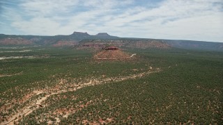 AX136_126E - 5.5K aerial stock footage of flying toward a butte, mesas, State Route 275 in Manti-La Sal National Forest, Utah