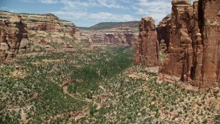 AX136_154 - 5.5K aerial stock footage of near tall rock formations in Arch Canyon, Utah