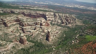 AX136_171 - 5.5K aerial stock footage pan right across canyon with rock formations and trees, Manti-La Sal National Forest, Utah