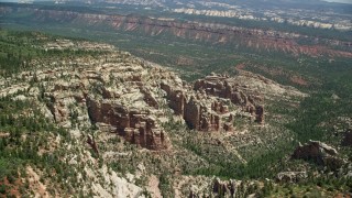 AX136_177E - 5.5K aerial stock footage of orbiting rock formations in a forested canyon, Manti-La Sal National Forest, Utah
