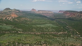 AX136_188E - 5.5K aerial stock footage of a canyon, approach buttes and mesas, Manti-La Sal National Forest, Utah