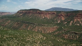 AX136_192 - 5.5K aerial stock footage of flying by a canyon below mesa, Manti-La Sal National Forest, Utah