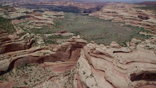 AX136_202 - 5.5K aerial stock footage of flying over box canyon, approaching green valley, Canyonlands National Park, Utah