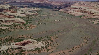 AX136_203 - 5.5K aerial stock footage of flying over valley surrounded by rock formations in Canyonlands National Park, Utah