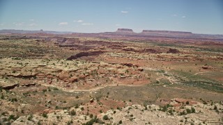 AX136_229E - 5.5K aerial stock footage of flying over rock formations and Big Spring Canyon, Canyonlands National Park, Utah