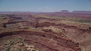AX136_230 - 5.5K aerial stock footage of flying over rock formations and Big Spring Canyon, Canyonlands National Park, Utah