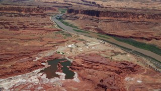 AX136_275 - 5.5K aerial stock footage of approaching Intrepid Potash plant by Colorado River, Moab, Utah