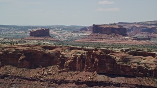 AX136_289 - 5.5K aerial stock footage of flying by Monitor Butte and Merrimac Butte, Moab, Utah