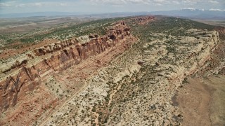 AX137_032E - 5.5K aerial stock footage flyby cliffside rock formations in Eagle Park, Arches National Park, Utah