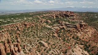 AX137_037E - 5.5K aerial stock footage of passing rock formations and desert vegetation, Eagle Park, Arches National Park, Utah