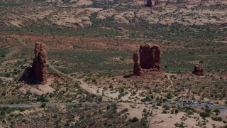 AX137_066 - 5.5K aerial stock footage of a close orbit of Balanced Rock and Arches Scenic Drive, Arches National Park, Utah