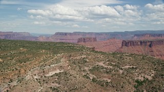 AX137_082E - 5.5K aerial stock footage of mesas and buttes seen from the top of Dry Mesa, Moab, Utah