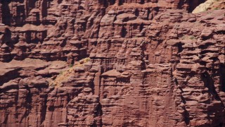 AX137_115E - 5.5K aerial stock footage of orbiting rock climbers on a formation at Fisher Towers, Utah