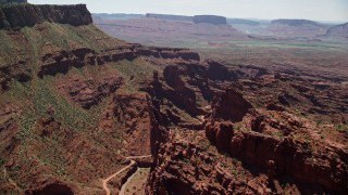 AX137_122E - 5.5K aerial stock footage of flying over dirt path through canyon in Fisher Towers, Utah