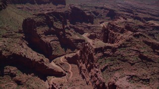 AX137_123 - 5.5K stock footage aerial video of flying over dirt path through canyon in Fisher Towers, Utah
