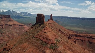 AX137_135E - 5.5K aerial stock footage flyby a butte to approach Castleton Tower in Moab, Utah