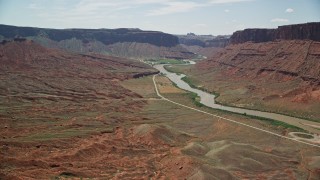 AX137_150E - 5.5K aerial stock footage of flying toward a large mesa by the Colorado River in Moab, Utah