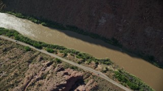 AX138_007E - 5.5K aerial stock footage of a bird's eye of a desert road by the Colorado River in Moab, Utah