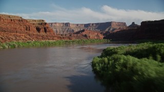 AX138_105E - 5.5K aerial stock footage fly low through Meander Canyon over Colorado River, Canyonlands National Park, Utah