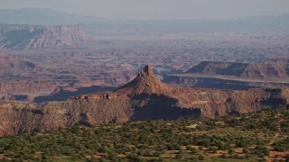 AX138_150E - 5.5K aerial stock footage of a lone butte in Shafer Canyon, Canyonlands National Park, Utah
