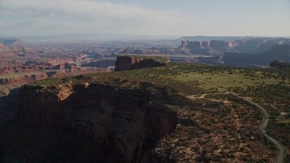 AX138_155E - 5.5K aerial stock footage approach and tilt to cars parked on Dead Horse Point Overlook with view of Canyonlands National Park, Utah