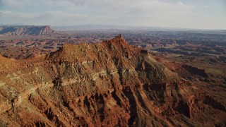 AX138_175E - 5.5K aerial stock footage orbit small butte with wide view of Canyonlands National Park, Utah
