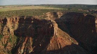 AX138_210E - 5.5K aerial stock footage of a bird's eye view of the top of canyon cliff and then fly away in Moab, Utah