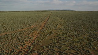 AX138_228E - 5.5K aerial stock footage fly over open desert and dirt road near Moab, Utah