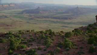 AX138_257 - 5.5K stock footage aerial video tilt to reveal South Six-Shooter Peak, North Six-Shooter Peak, hazy valley, Moab, Utah