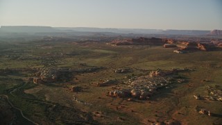 AX138_285E - 5.5K aerial stock footage of flying by desert rock formations and distant tall cliffs, Canyonlands National Park, Utah