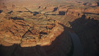 AX138_299 - 5.5K aerial stock footage of passing The Loop West in Meander Canyon and Colorado River, Canyonlands National Park, Utah, sunset