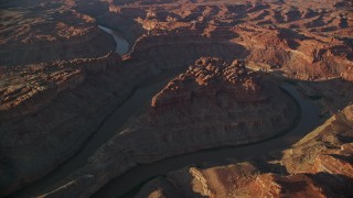 AX138_304E - 5.5K aerial stock footage orbiting the river in The Loop East part of Meander Canyon, Canyonlands National Park, Utah, sunset