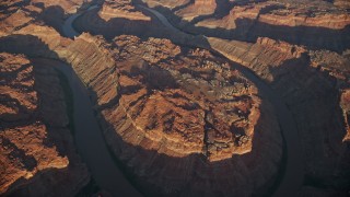 AX138_321E - 5.5K aerial stock footage of a bird's eye of the river in Meander Canyon at sunset, Canyonlands National Park, Utah