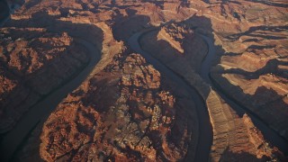 AX138_324E - 5.5K aerial stock footage of an orbit of the river at sunset, bottom of Meander Canyon, Canyonlands National Park, Utah