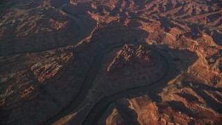 AX138_327E - 5.5K aerial stock footage circle the Colorado River in Meander Canyon at sunset, Canyonlands National Park, Utah