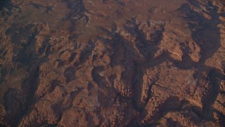AX138_337 - 5.5K aerial stock footage of a bird's eye view of dry riverbeds through rocky canyons, Canyonlands National Park, Utah, sunset