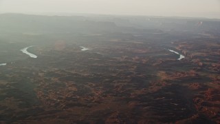 AX138_340 - 5.5K aerial stock footage of flying by the Colorado River in Meander Canyon, Canyonlands National Park, Utah, sunset