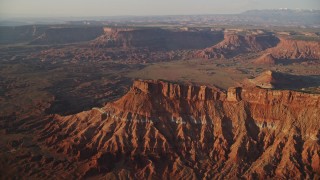 AX138_341E - 5.5K aerial stock footage of orbiting a butte near Lockhart Canyon, Moab, Utah, sunset