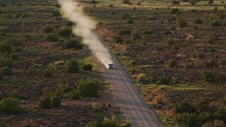 AX138_358 - 5.5K aerial stock footage video of an SUV on Hatch Point Road, Moab, Utah, sunset