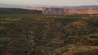 AX138_359E - 5.5K aerial stock footage of panning across canyon, seen from Hatch Point, Moab, Utah, sunset