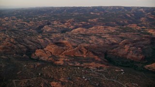 AX138_378E - 5.5K aerial stock footage of flying over petrified sand dunes, Sand Flats Recreation Area, Utah, sunset
