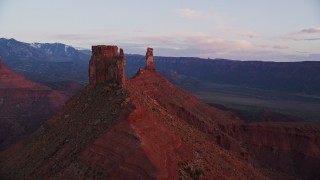 AX138_414E - 5.5K aerial stock footage of approaching and orbiting Castleton Tower at sunset, Moab, Utah