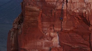AX138_419E - 5.5K aerial stock footage of a rock climber on Castleton Tower, Moab, Utah, sunset