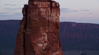 AX138_423 - 5.5K aerial stock footage of an orbit around a rock climber on Castleton Tower, Moab, Utah, sunset