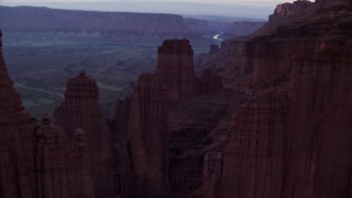 AX138_435E - 5.5K aerial stock footage fly over rock formations, approach Colorado River and canyon, Fisher Towers, Utah, twilight