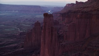 AX138_444E - 5.5K aerial stock footage of flying over The Titan, Echo Tower, approaching Ancient Art, Fisher Towers, Utah, twilight