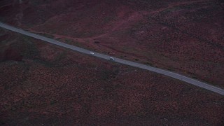 AX138_454 - 5.5K aerial stock footage of tracking sedan and SUV on State Route 128 through desert, Moab, Utah, twilight