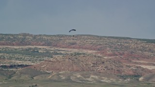 AX139_016E - 5.5K aerial stock footage of a skydiver landing in Canyonlands Field, Utah