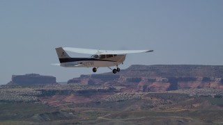 AX139_023 - 5.5K aerial stock footage of tracking Cessna flying over desert, Grand County, Utah